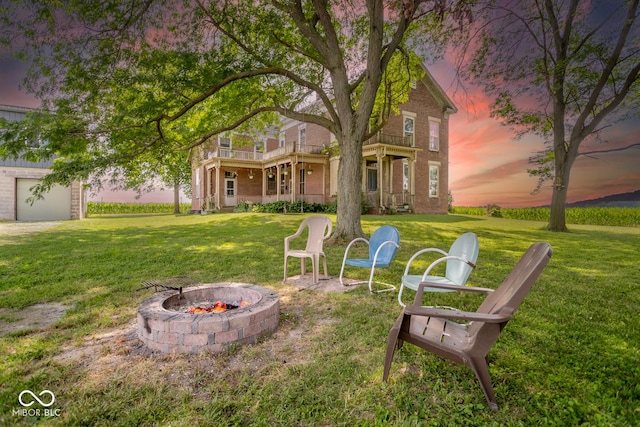9665 N County Rd 250 E, Frankfort, IN 46041 - yard at dusk with a balcony, an outdoor fire pit, and a lawn