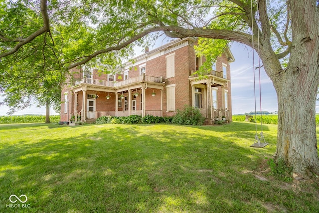 9665 N County Rd 250 E, Frankfort, IN 46041 - rear view of house featuring a balcony, brick siding, a yard, and a porch