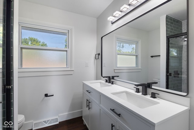 4622 S Franklin Rd, Indianapolis, IN 46239 - bathroom featuring double vanity, wood finished floors, and a tile shower