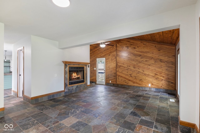 4622 S Franklin Rd, Indianapolis, IN 46239 - unfurnished living room with stone tile floors, wooden walls, and a warm lit fireplace