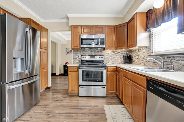8413 Slippery Elm Ct, Indianapolis, IN 46227 - kitchen with appliances with stainless steel finishes, crown molding, light wood-style floors, light countertops, and backsplash
