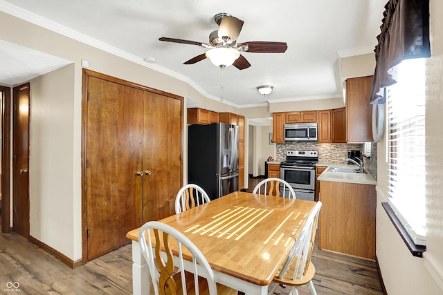 8413 Slippery Elm Ct, Indianapolis, IN 46227 - dining room with light wood finished floors, ceiling fan, and crown molding