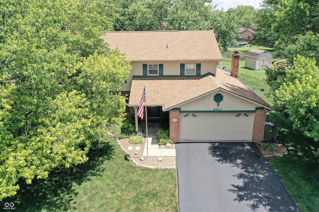 8413 Slippery Elm Ct, Indianapolis, IN 46227 - view of front facade featuring a shingled roof, driveway, brick siding, a front lawn, and a garage