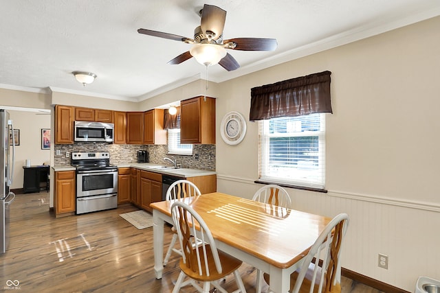 8413 Slippery Elm Ct, Indianapolis, IN 46227 - kitchen with appliances with stainless steel finishes, light countertops, wood finished floors, a ceiling fan, and backsplash