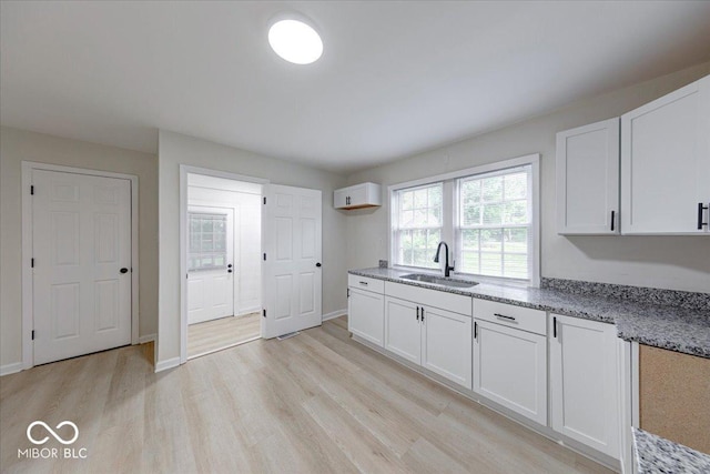 3725 Carson Ave, Indianapolis, IN 46227 - kitchen with light wood-type flooring, light stone countertops, and white cabinetry
