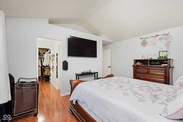 6136 Sandcherry Dr, Indianapolis, IN 46236 - bedroom with vaulted ceiling, light wood finished floors, and a walk in closet