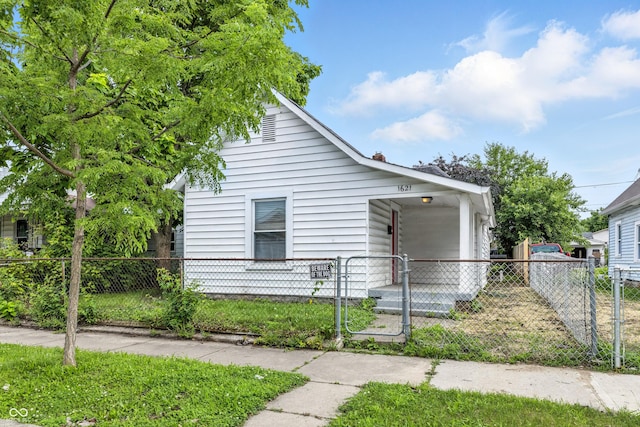 1621 E Kelly St, Indianapolis, IN 46203 - bungalow-style home featuring a fenced front yard, a gate, and a carport
