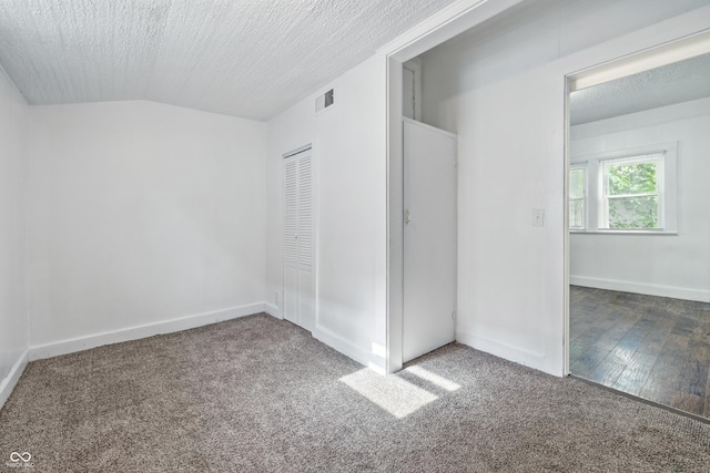 1621 E Kelly St, Indianapolis, IN 46203 - unfurnished bedroom featuring carpet floors, a closet, lofted ceiling, and a textured ceiling