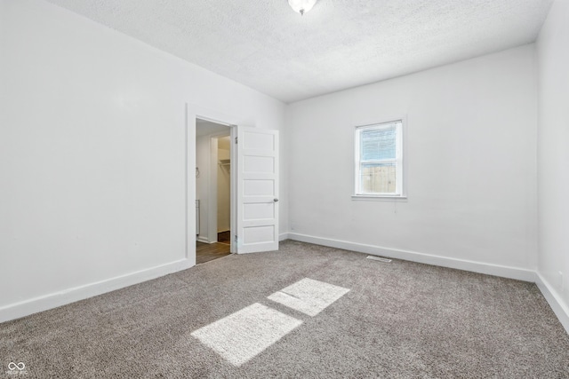 1621 E Kelly St, Indianapolis, IN 46203 - unfurnished bedroom with carpet flooring, a textured ceiling, and a walk in closet