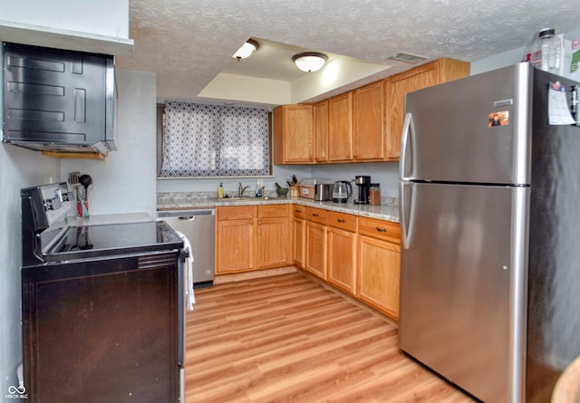 2725 Palo Verde Ct, Indianapolis, IN 46227 - kitchen featuring stainless steel appliances, light wood finished floors, light countertops, a textured ceiling, and a raised ceiling