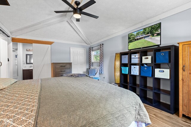 296 Summit Ridge Dr, Greenwood, IN 46142 - bedroom featuring vaulted ceiling, wood finished floors, a textured ceiling, ensuite bathroom, and ceiling fan