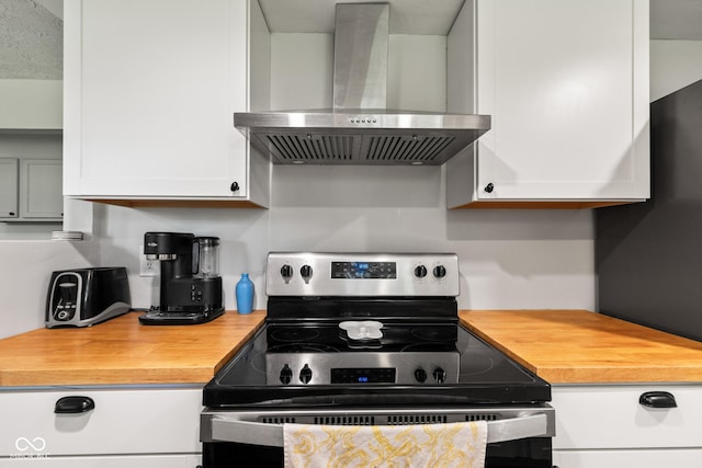 296 Summit Ridge Dr, Greenwood, IN 46142 - kitchen featuring stainless steel electric range, wall chimney exhaust hood, butcher block counters, and white cabinets