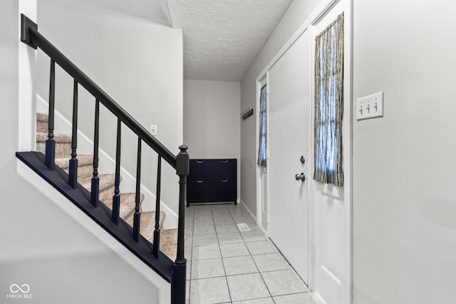 296 Summit Ridge Dr, Greenwood, IN 46142 - foyer entrance featuring tile patterned floors, a textured ceiling, and stairs