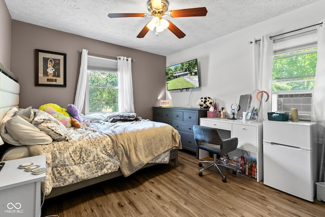 296 Summit Ridge Dr, Greenwood, IN 46142 - bedroom featuring white refrigerator, multiple windows, a textured ceiling, light wood-style floors, and a ceiling fan