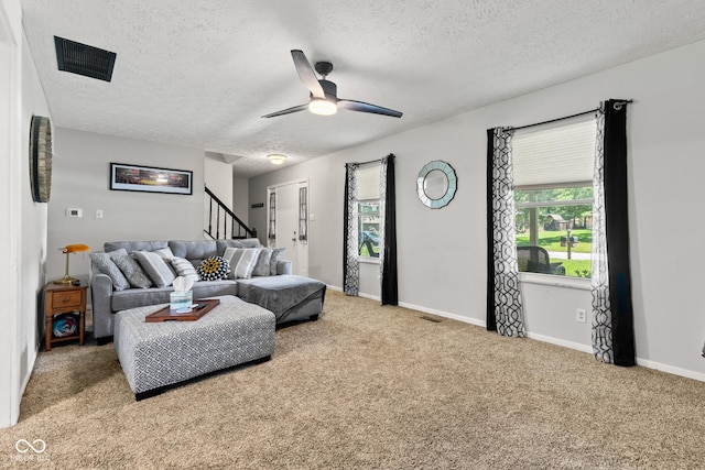 296 Summit Ridge Dr, Greenwood, IN 46142 - carpeted living area with a textured ceiling, stairway, and a ceiling fan