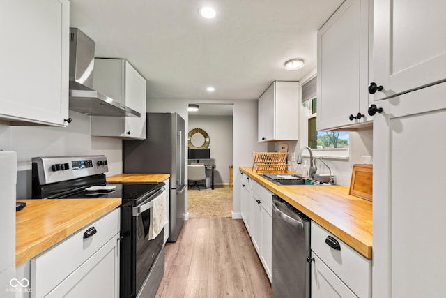 296 Summit Ridge Dr, Greenwood, IN 46142 - kitchen featuring wooden counters, stainless steel appliances, wall chimney exhaust hood, light wood-type flooring, and recessed lighting