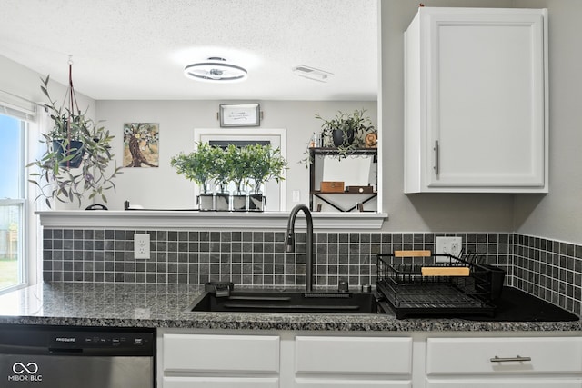 8147 Retreat Ln, Indianapolis, IN 46259 - kitchen featuring stainless steel dishwasher, tasteful backsplash, white cabinets, and a textured ceiling