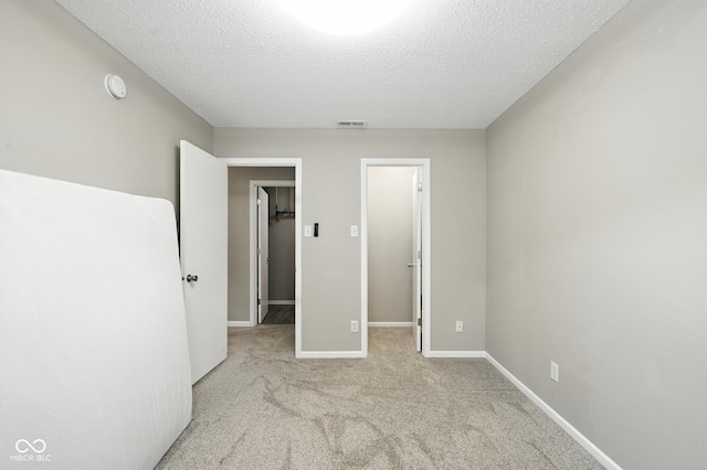 8147 Retreat Ln, Indianapolis, IN 46259 - unfurnished bedroom featuring a walk in closet, carpet flooring, and a textured ceiling