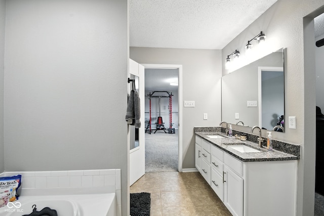 8147 Retreat Ln, Indianapolis, IN 46259 - bathroom featuring double vanity, a bathtub, a textured ceiling, and tile patterned flooring