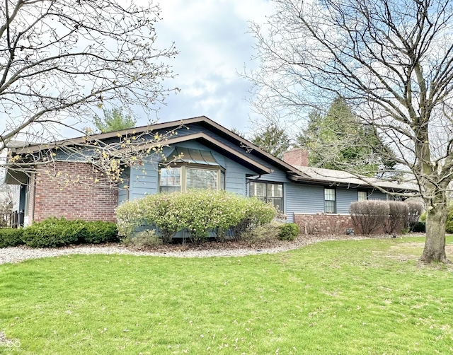 401 Dellwood Dr, Covington, IN 47932 - view of home's exterior with a lawn, a chimney, and brick siding