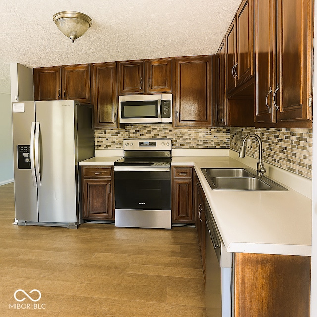 3911 Eastwind St, Indianapolis, IN 46237 - kitchen with stainless steel appliances, light countertops, light wood-style flooring, and a textured ceiling