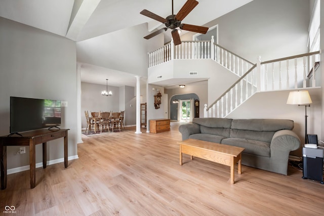 8365 Captain Dr, Avon, IN 46123 - living area with high vaulted ceiling, ceiling fan, light wood-style flooring, stairs, and a chandelier