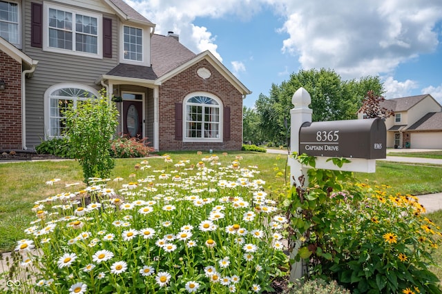 8365 Captain Dr, Avon, IN 46123 - view of front of house with brick siding, a front yard, and a shingled roof