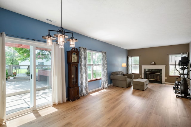8365 Captain Dr, Avon, IN 46123 - living room with light wood finished floors, a high end fireplace, and a chandelier