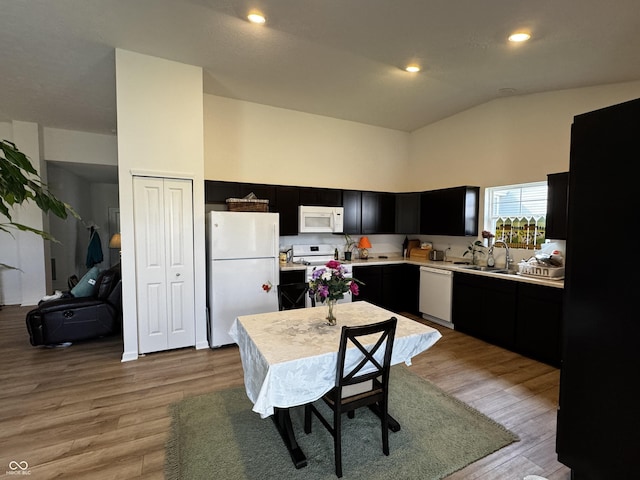 602 Tuscany Trl, Lapel, IN 46051 - kitchen featuring white appliances, dark cabinetry, light countertops, light wood-style floors, and high vaulted ceiling