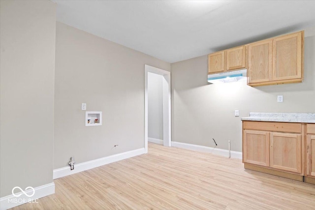 2813 S Monroe St, Muncie, IN 47302 - kitchen with light brown cabinetry, light wood-type flooring, light countertops, and under cabinet range hood