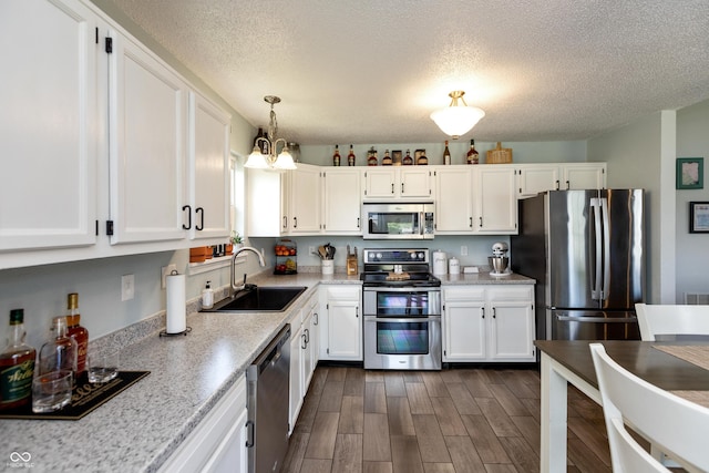2082 Fiesbeck Dr, Columbus, IN 47201 - kitchen featuring appliances with stainless steel finishes, a textured ceiling, white cabinetry, light countertops, and dark wood-style floors