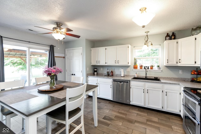 2082 Fiesbeck Dr, Columbus, IN 47201 - kitchen with appliances with stainless steel finishes, a textured ceiling, white cabinets, plenty of natural light, and a ceiling fan