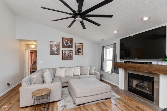 2082 Fiesbeck Dr, Columbus, IN 47201 - living room with lofted ceiling, a ceiling fan, a textured ceiling, a glass covered fireplace, and wood finished floors
