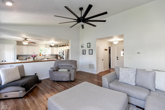 2082 Fiesbeck Dr, Columbus, IN 47201 - living room featuring vaulted ceiling, ceiling fan, and wood finished floors