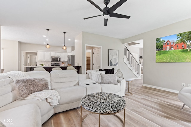 5910 Hickory Woods Dr, Plainfield, IN 46168 - living room with a ceiling fan, stairs, light wood-type flooring, and recessed lighting
