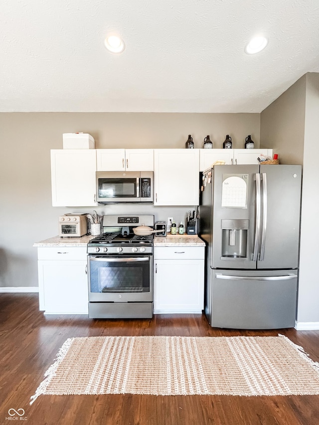 258 Center Ln, Crawfordsville, IN 47933 - kitchen featuring stainless steel appliances, white cabinets, light countertops, and dark wood finished floors