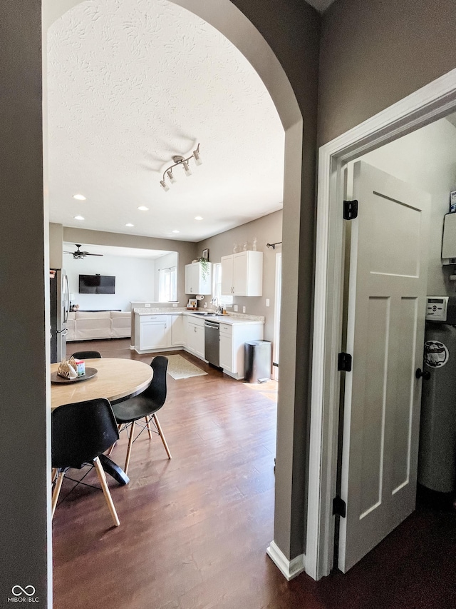 258 Center Ln, Crawfordsville, IN 47933 - kitchen featuring appliances with stainless steel finishes, arched walkways, dark wood-style floors, white cabinets, and ceiling fan