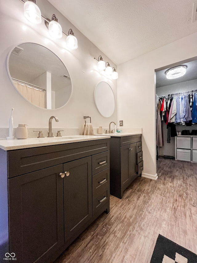 258 Center Ln, Crawfordsville, IN 47933 - full bath featuring vanity, wood finished floors, a walk in closet, and a textured ceiling