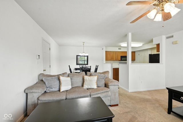 3096 Wildcat Ln, Indianapolis, IN 46203 - living area featuring light carpet, a ceiling fan, and a chandelier