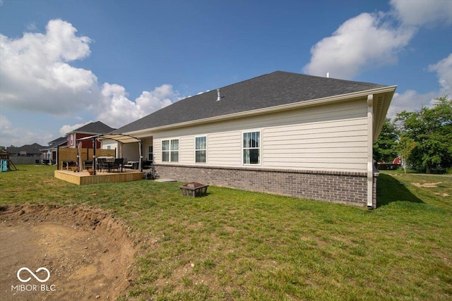1615 N Blue Rd, Greenfield, IN 46140 - rear view of house featuring brick siding, a lawn, a deck, and an outdoor fire pit
