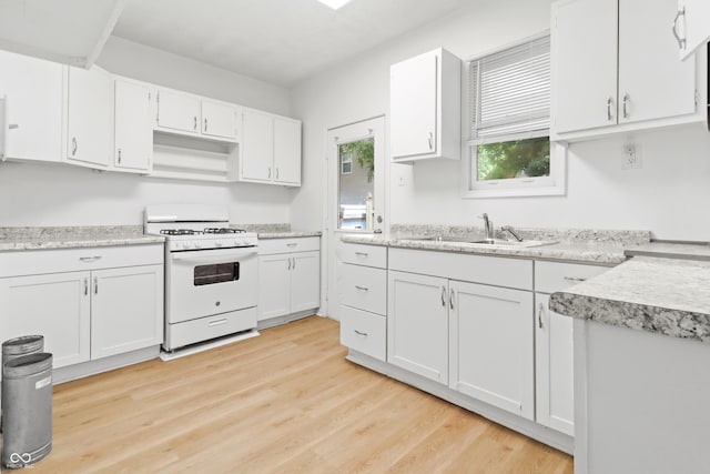 525 N Concord St N, Indianapolis, IN 46222 - kitchen with white gas range oven, white cabinets, light countertops, and light wood-style floors