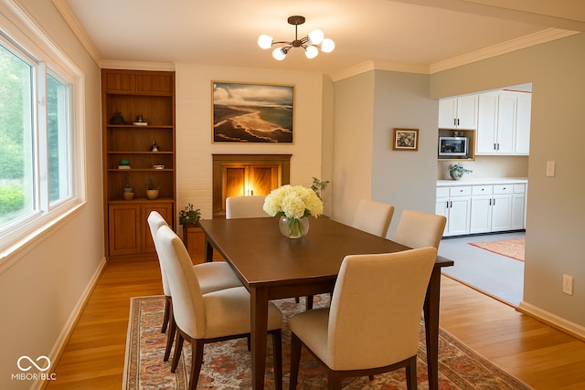6209 N Parker St, Indianapolis, IN 46220 - dining area featuring plenty of natural light, light wood-style flooring, a chandelier, and crown molding