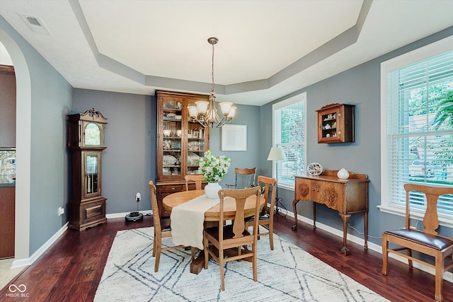 823 Colin Dr, Avon, IN 46123 - dining room featuring arched walkways, a tray ceiling, wood finished floors, and a chandelier