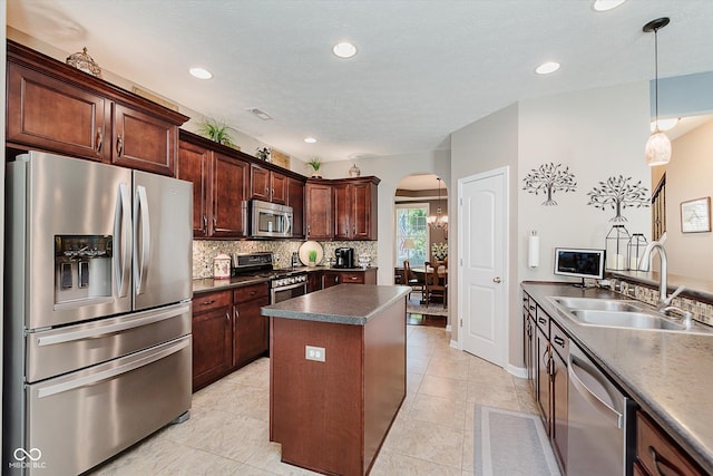 823 Colin Dr, Avon, IN 46123 - kitchen featuring stainless steel appliances, arched walkways, dark countertops, a kitchen island, and tasteful backsplash