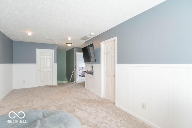 10450 Wintergreen Way, Indianapolis, IN 46234 - spare room with wainscoting, light colored carpet, and a textured ceiling