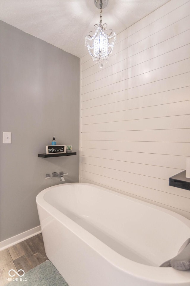 10450 Wintergreen Way, Indianapolis, IN 46234 - full bathroom featuring a bath, wood finished floors, and a chandelier