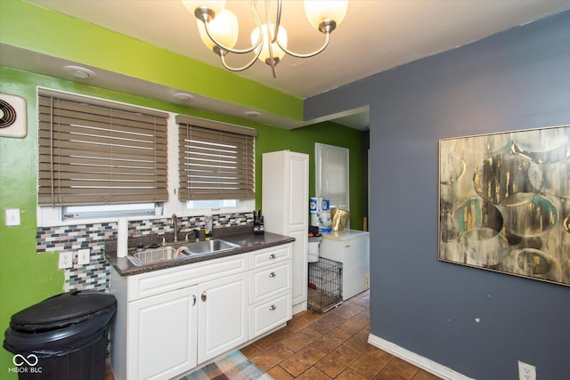 3459 W Michigan St, Indianapolis, IN 46222 - kitchen featuring dark countertops, tasteful backsplash, white cabinetry, and a chandelier