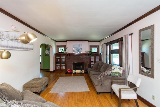 3459 W Michigan St, Indianapolis, IN 46222 - living room with arched walkways, hardwood / wood-style floors, ornamental molding, and a brick fireplace