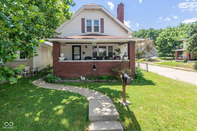 3459 W Michigan St, Indianapolis, IN 46222 - bungalow with covered porch, brick siding, a chimney, and a front lawn