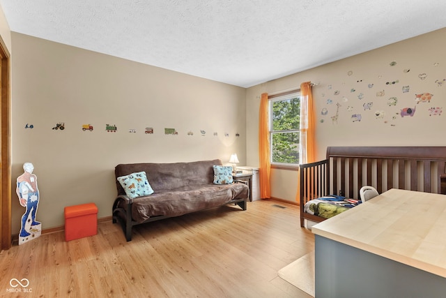 7621 Forest Dr, Fishers, IN 46038 - bedroom featuring light wood-style floors and a textured ceiling